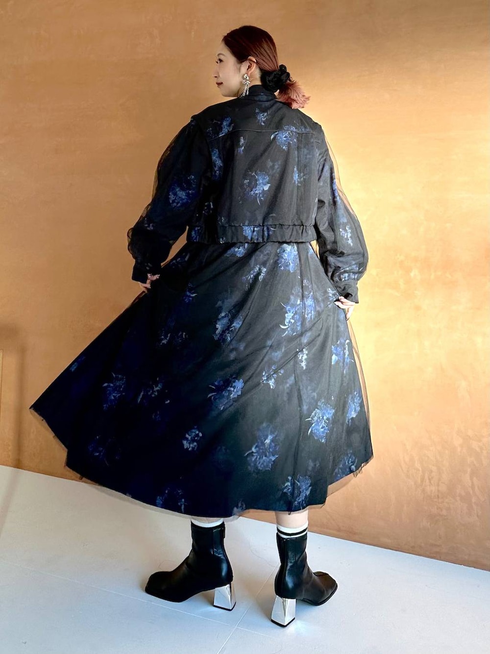 ブラック系のブーツ、ブラック系のブルゾン、ブラック系のワンピースを着用したレディースの冬コーディネートの2枚目の写真