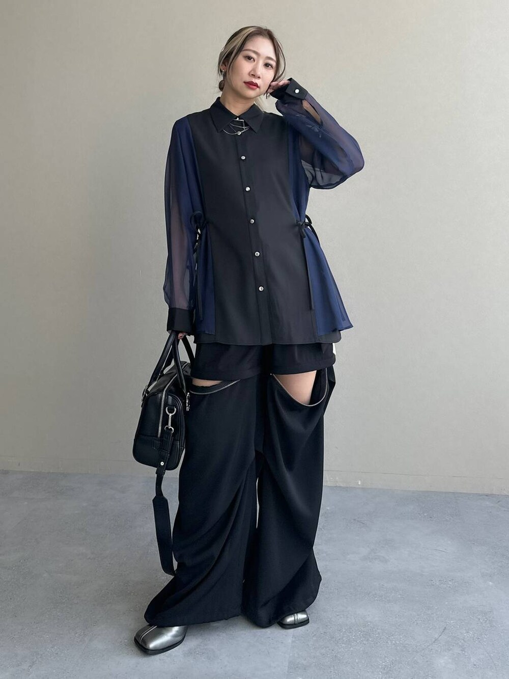 ブラック系のカーゴパンツ、ブラック系のボストンバッグ、シルバー系のブーツを着用したレディースの夏コーディネートの8枚目の写真