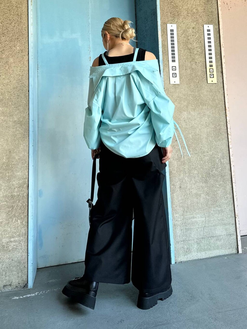 ブラック系のサンダル、ブルー系のシャツ/ブラウス、ブラック系のブレスレットを着用したレディースの春コーディネートの2枚目の写真