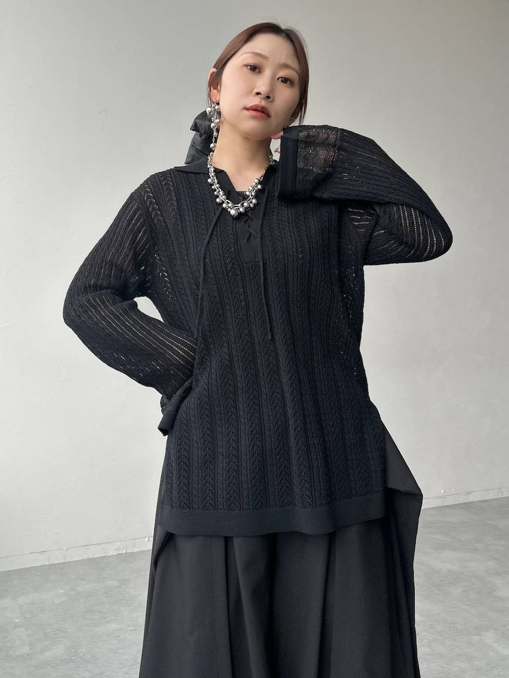 ブラック系のサンダル、ブラック系のニット/セーター、ブラック系のスラックスを着用したレディースの春コーディネートの3枚目の写真