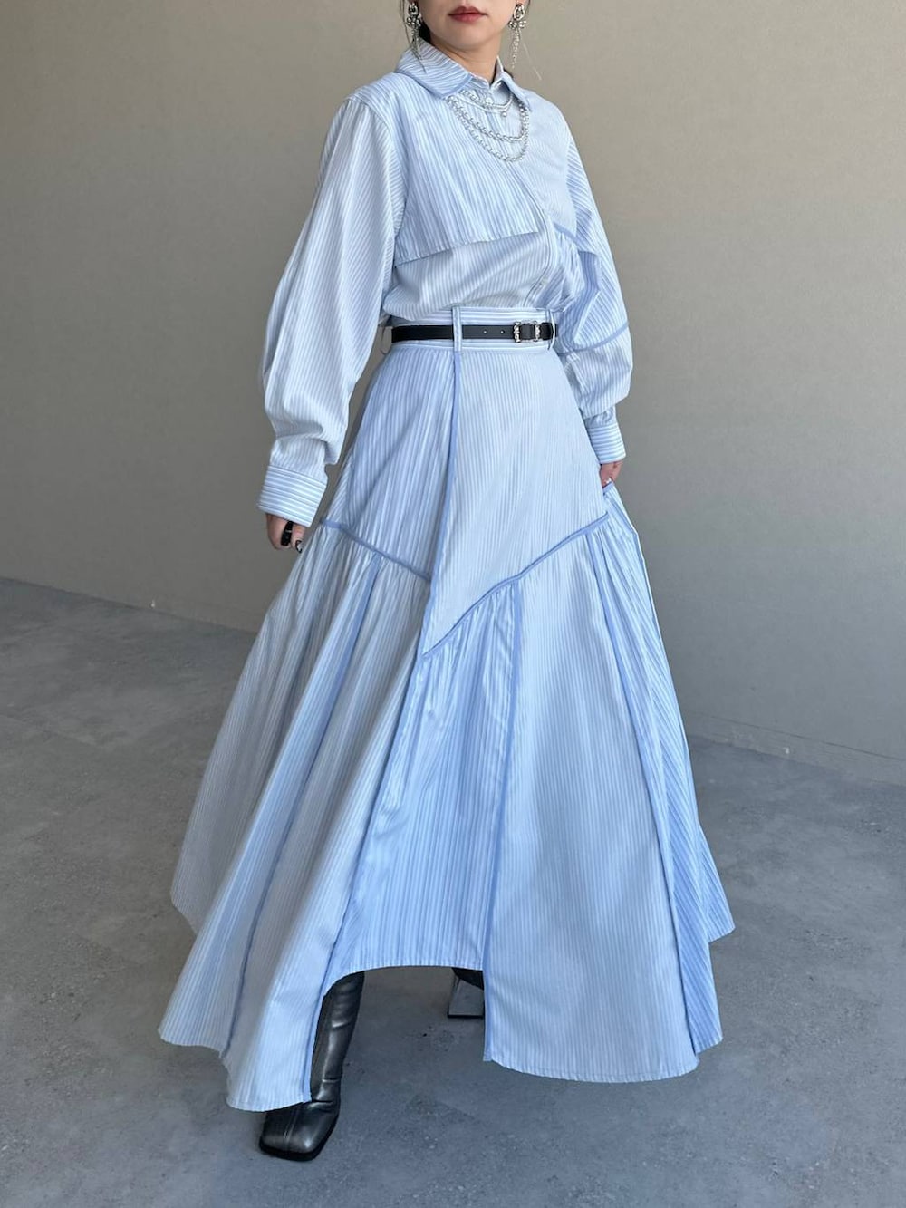 ブラック系のショルダーバッグ、シルバー系のブーツ、ブルー系のスカートを着用したレディースの冬コーディネートの7枚目の写真