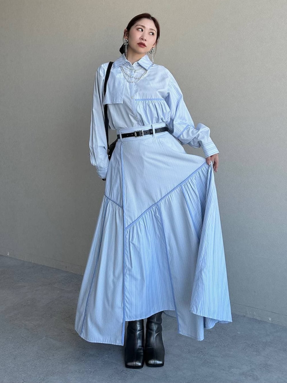 ブラック系のショルダーバッグ、シルバー系のブーツ、ブルー系のスカートを着用したレディースの冬コーディネートの9枚目の写真