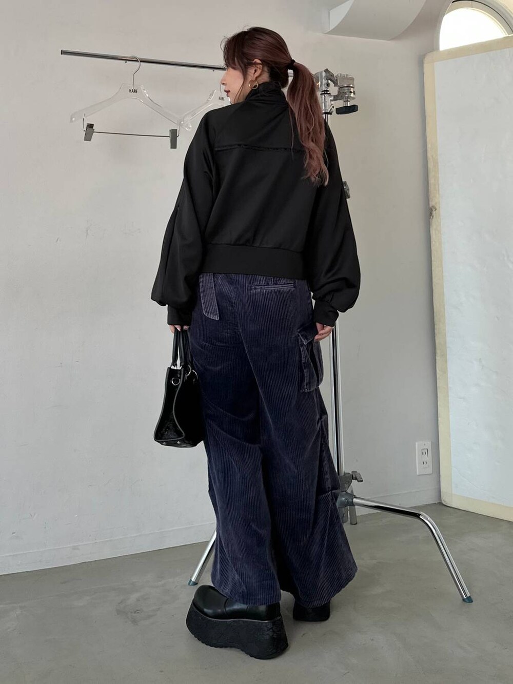 ブラック系のショルダーバッグ、ブルー系のパーカー、ブルー系のカーゴパンツを着用したレディースの秋コーディネートの2枚目の写真