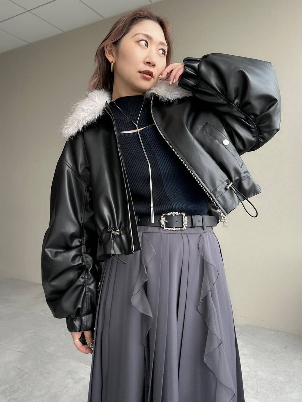 シルバー系のブーツ、ブラック系のニット/セーター、ブラック系のベルトを着用したレディースの秋コーディネートの3枚目の写真