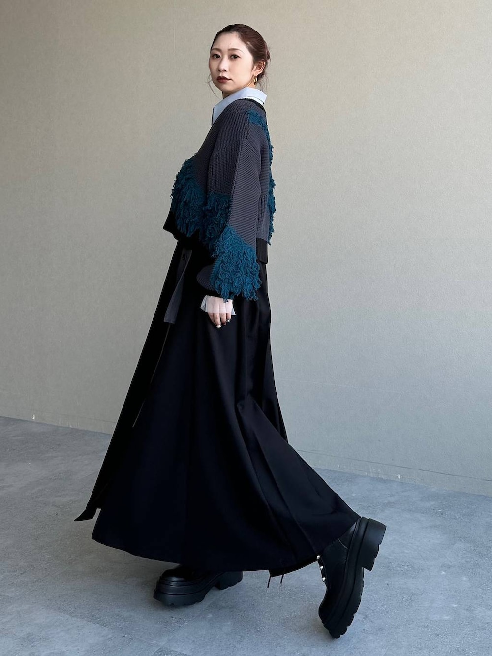 ブラック系のスカート、ブルー系のニット/セーターを着用したレディースの冬コーディネートの2枚目の写真