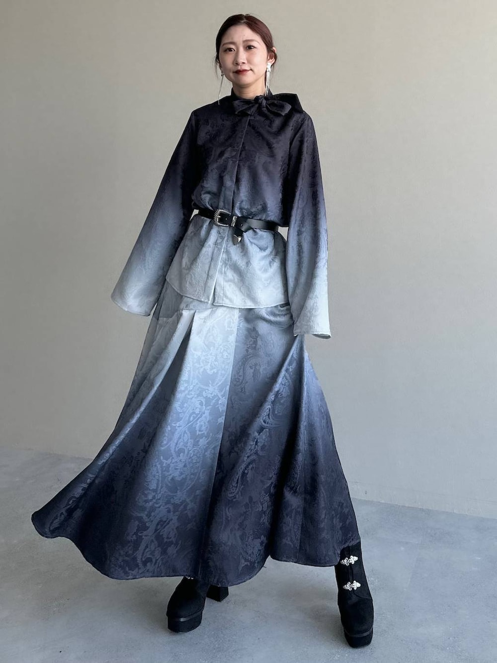 ブラック系のブーツ、ブラック系のシャツ/ブラウス、ブラック系のスカートを着用したレディースの冬コーディネートの7枚目の写真