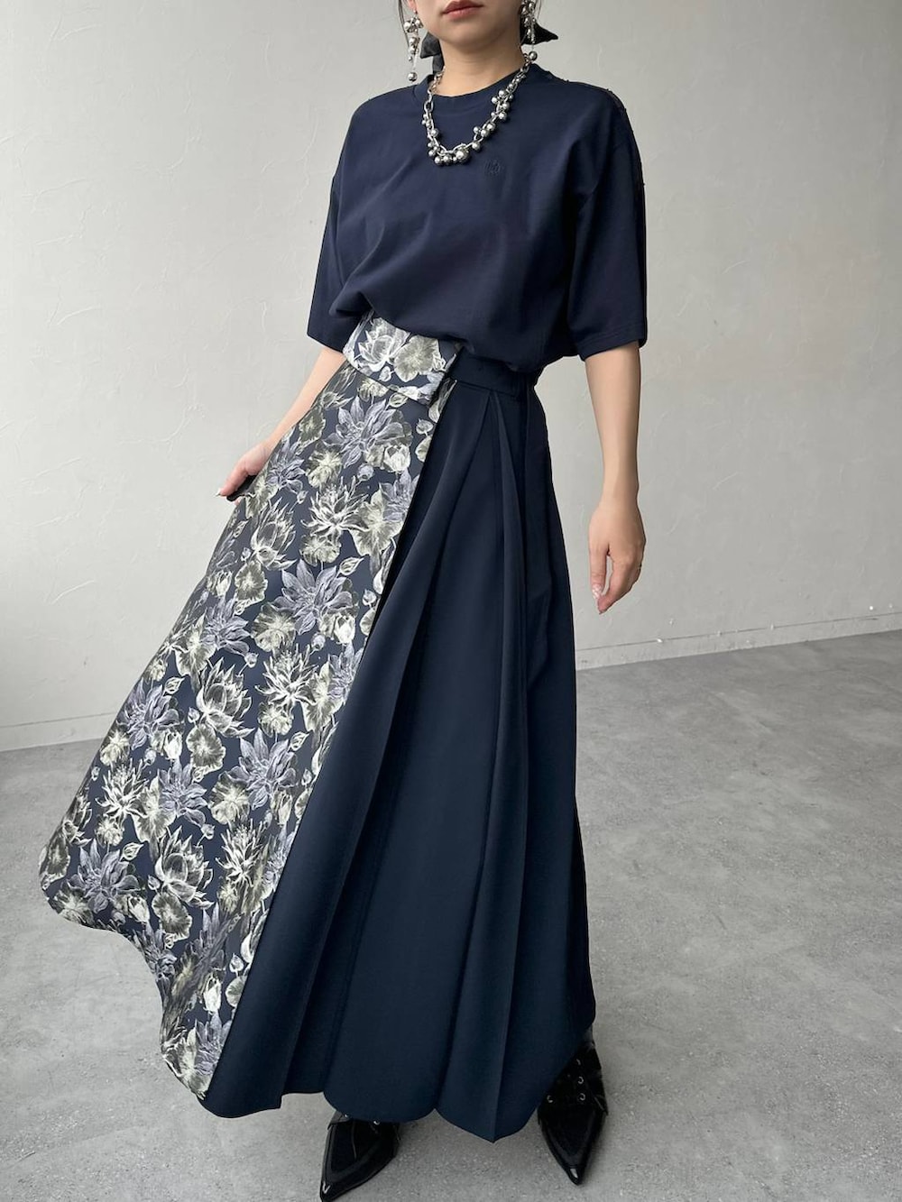 ブラック系のサンダル、ブラック系のハンドバッグ、ブルー系のスカートを着用したレディースの春コーディネートの6枚目の写真