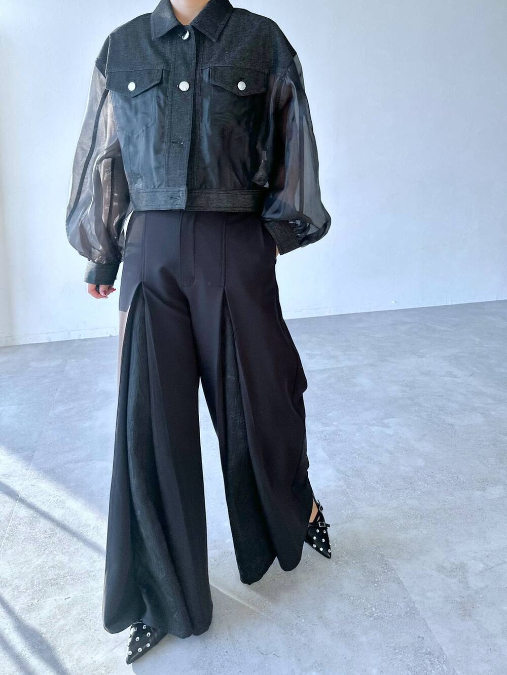 ブラック系のスラックス、ブラック系のパンプス、ブラック系のブルゾンを着用したレディースの夏コーディネートの5枚目の写真