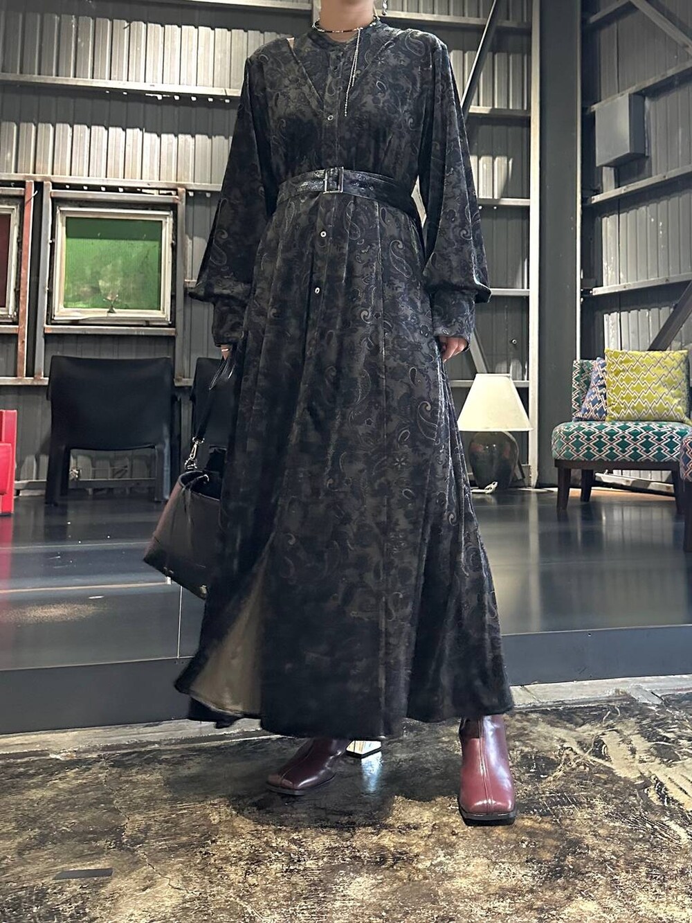 ブラック系のワンピース、レッド系のブーツ、ブラック系のショルダーバッグを着用したレディースの秋コーディネートの5枚目の写真