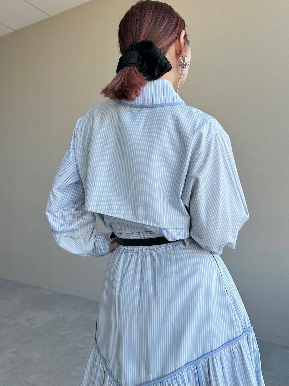 ブラック系のショルダーバッグ、シルバー系のブーツ、ブルー系のスカートを着用したレディースの冬コーディネートの5枚目の写真