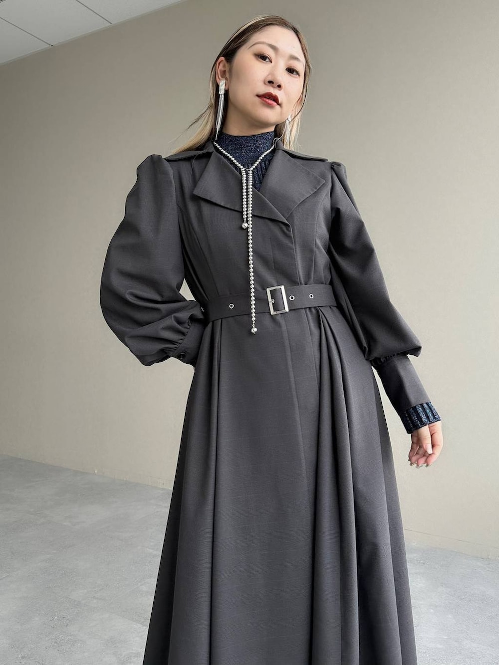 ブルー系のニット/セーター、ブラウン系のボストンバッグ、グレー系のワンピースを着用したレディースの秋コーディネートの3枚目の写真