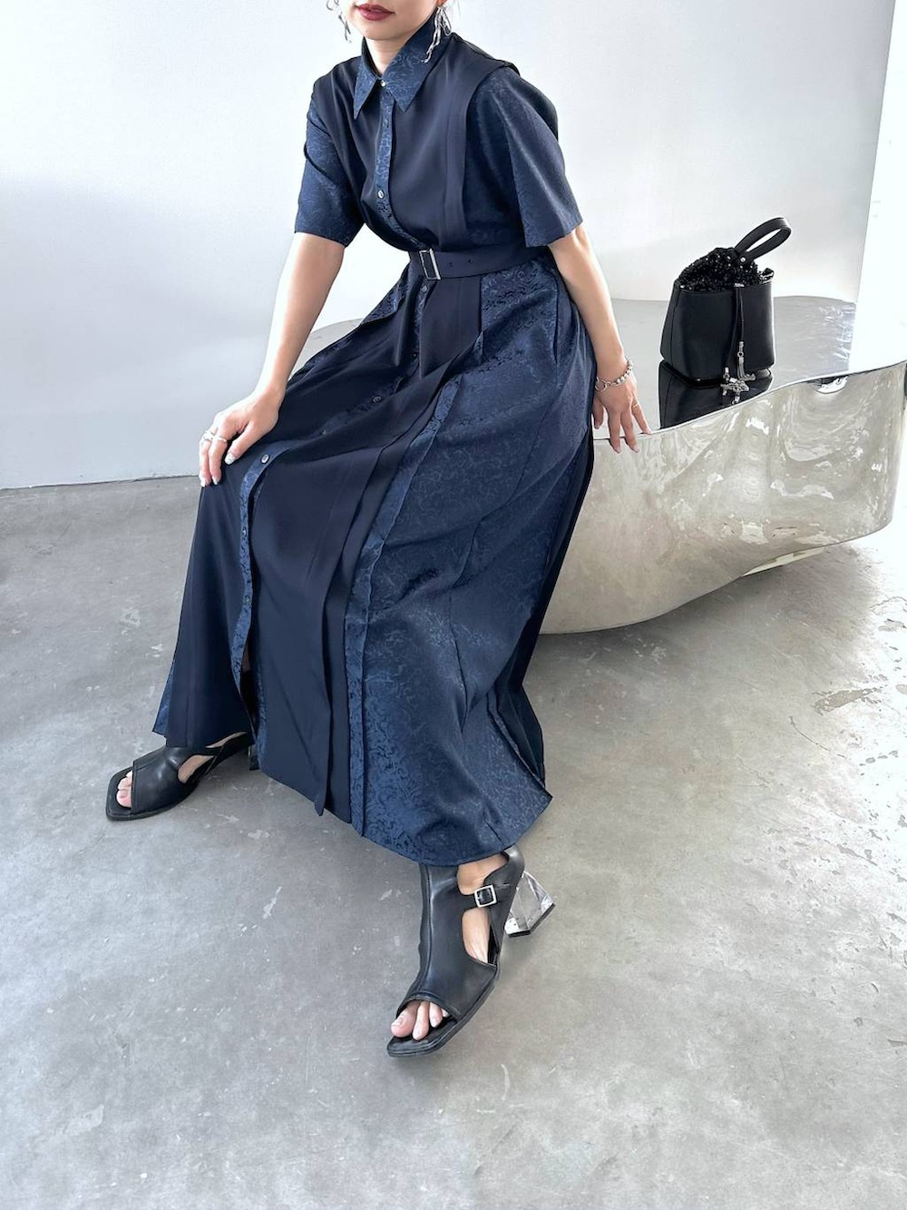 ブルー系のワンピース、ブラック系のショルダーバッグ、ブラック系のサンダルを着用したレディースの春コーディネートの2枚目の写真