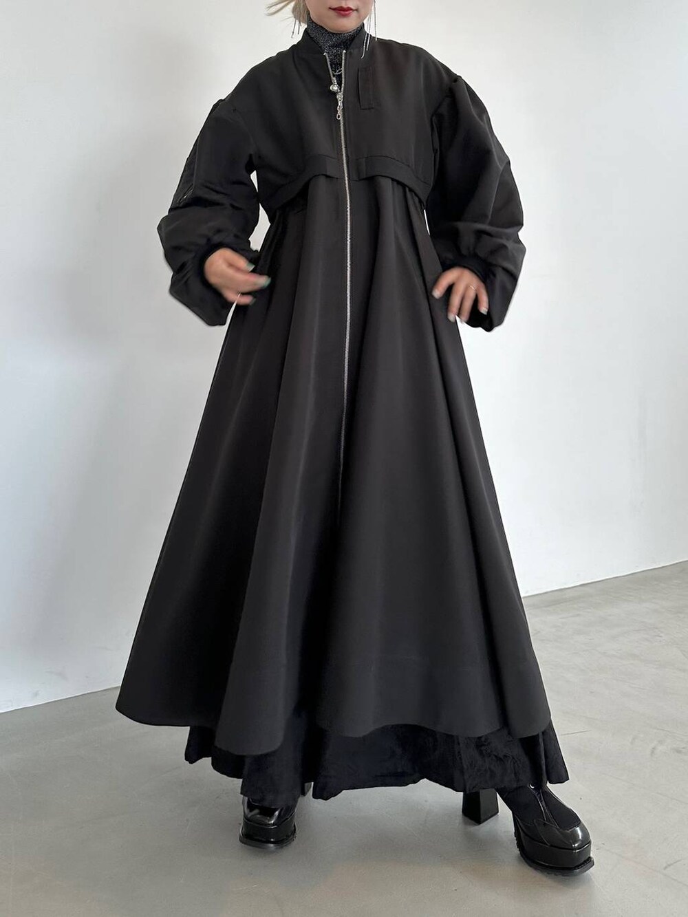 ブラック系のニット/セーター、ブラック系のブーツ、ブラック系のブルゾンを着用したレディースの秋コーディネートの6枚目の写真