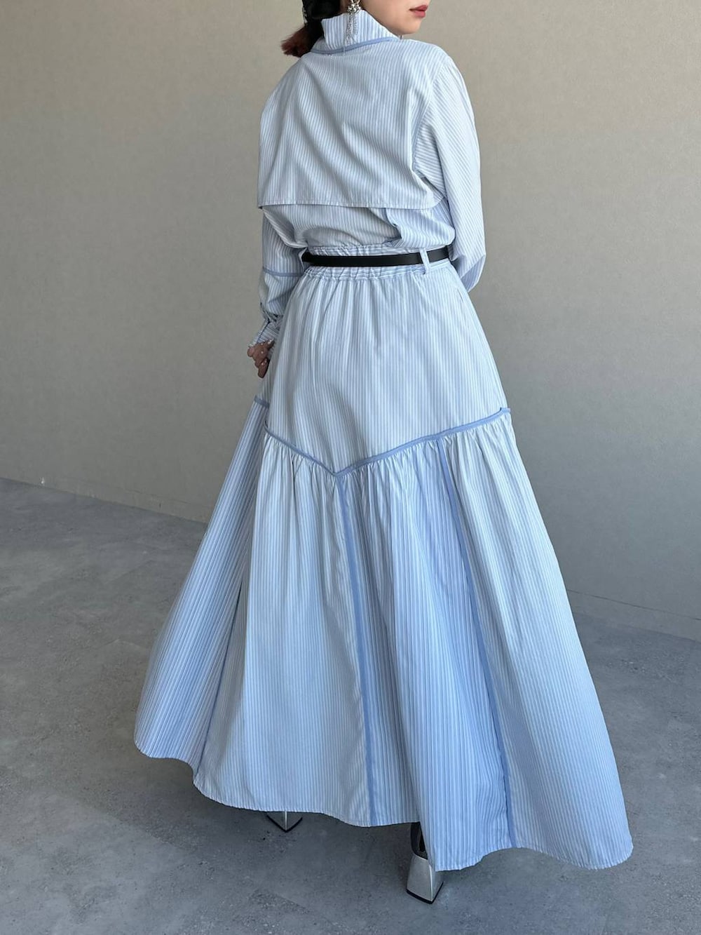 ブラック系のショルダーバッグ、シルバー系のブーツ、ブルー系のスカートを着用したレディースの冬コーディネートの8枚目の写真