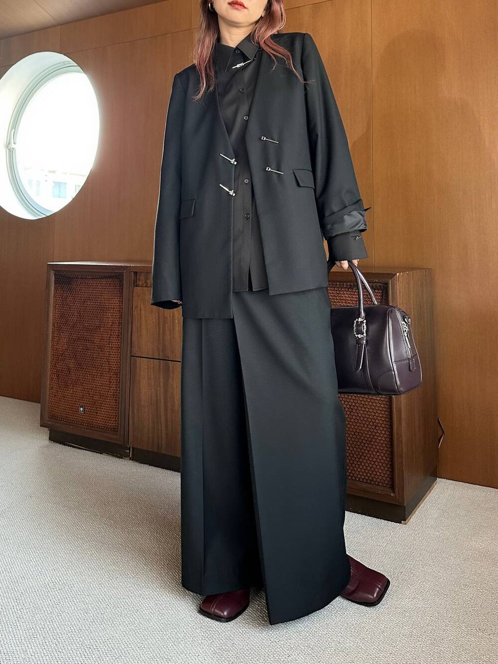 ブラウン系のボストンバッグ、レッド系のブーツを着用したレディースの秋コーディネートの8枚目の写真