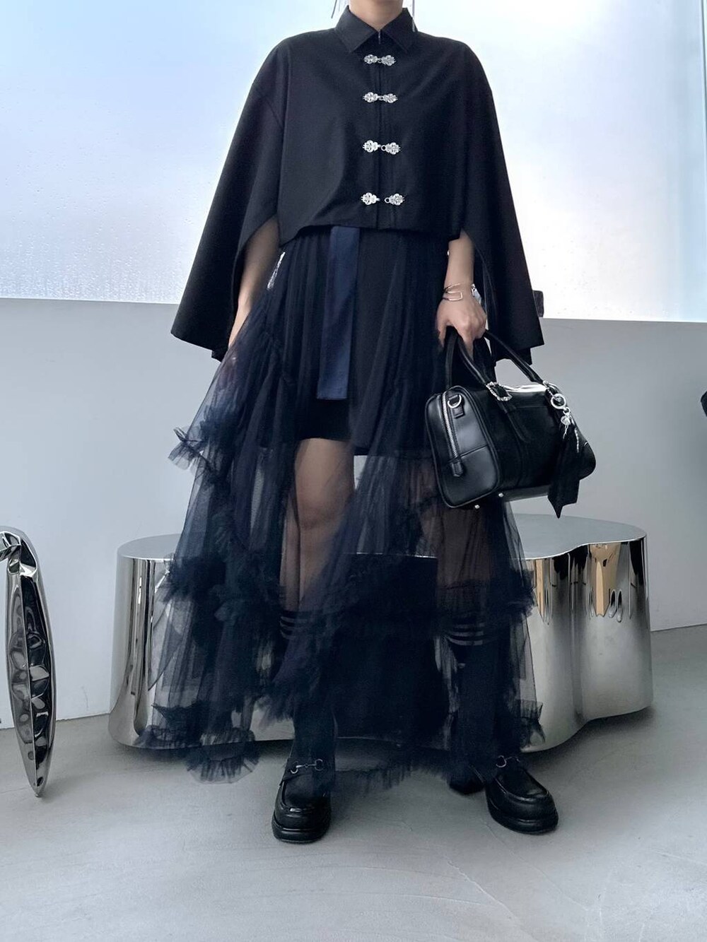 ブラック系のボストンバッグ、ブラック系のシャツ/ブラウス、ブラック系のローファーを着用したレディースの夏コーディネートの7枚目の写真