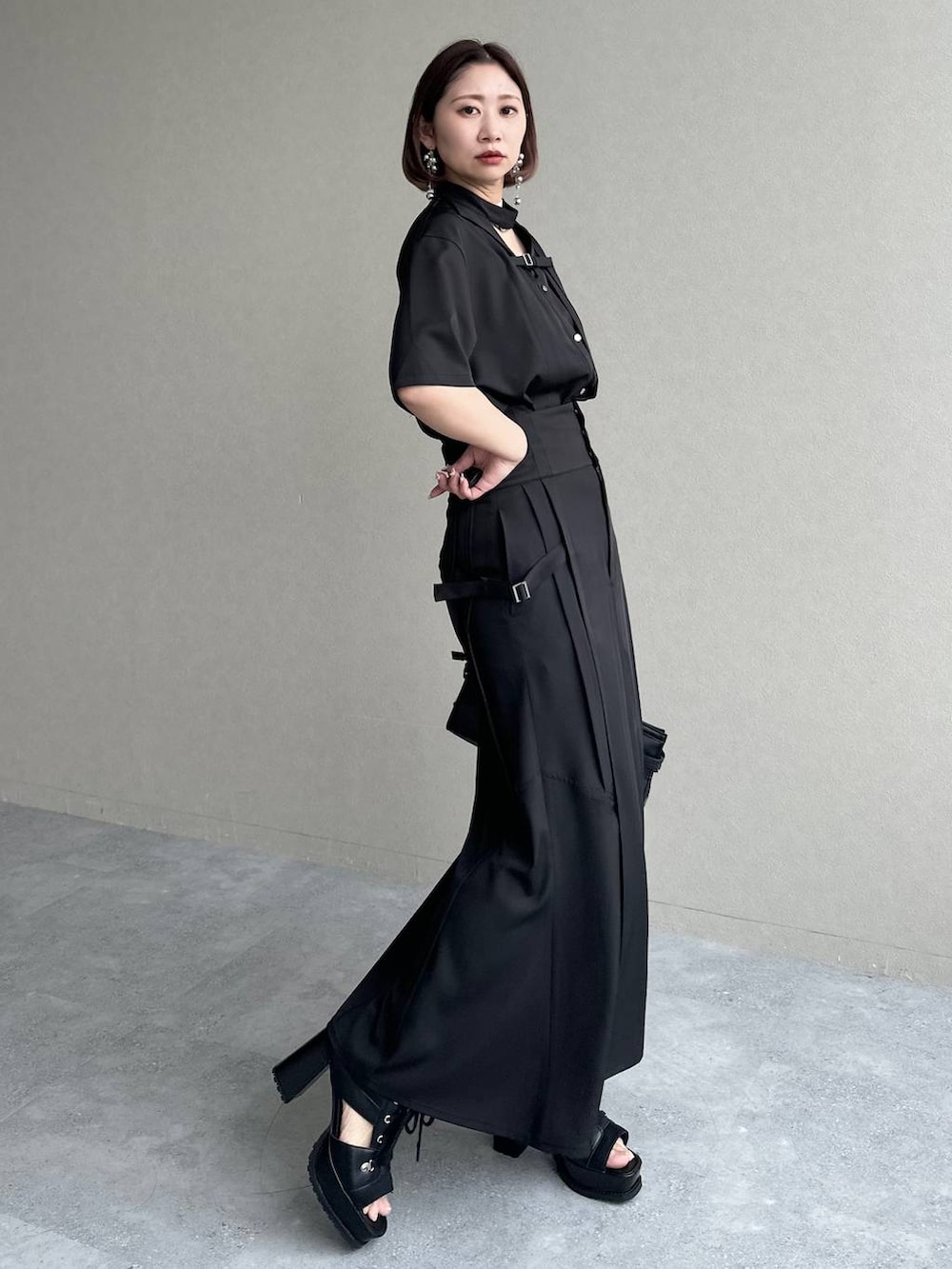 ブラック系のブーツ、ブラック系のシャツ/ブラウス、ブラック系のスカートを着用したレディースの春コーディネートの2枚目の写真