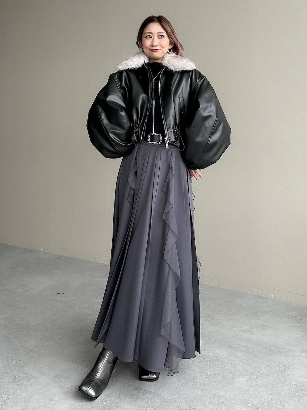 シルバー系のブーツ、ブラック系のニット/セーター、ブラック系のベルトを着用したレディースの秋コーディネートの9枚目の写真