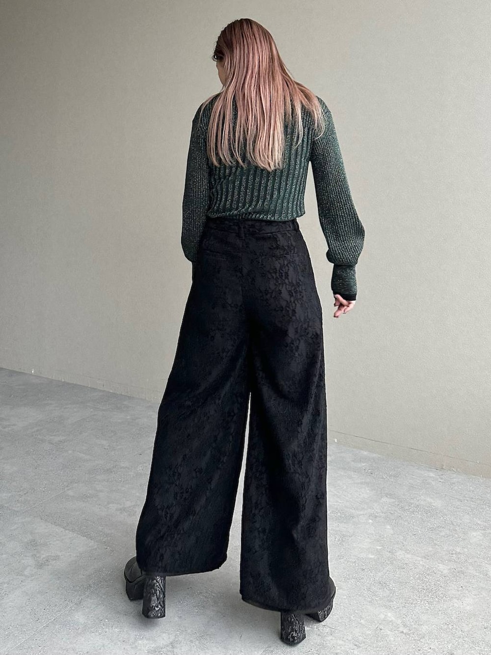 グレー系のブーツ、グリーン系のカーディガン/ボレロ、シルバー系のイヤリングを着用したレディースの秋コーディネートの2枚目の写真