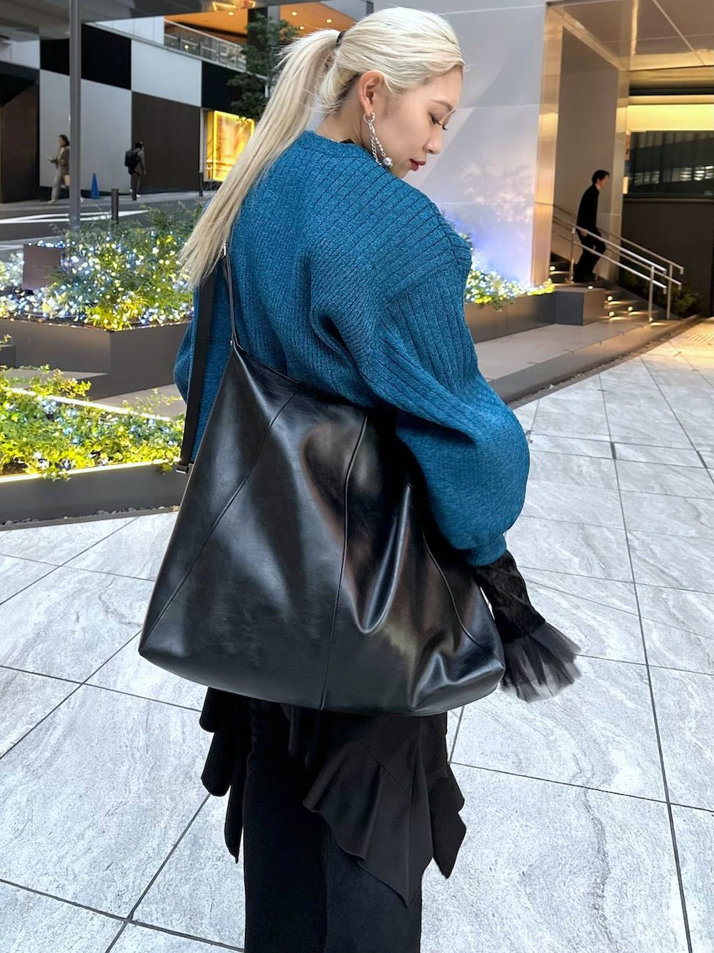 ブラック系のTシャツ/カットソー、ブラック系のブーツ、ブラック系のショルダーバッグを着用したレディースの冬コーディネートの6枚目の写真