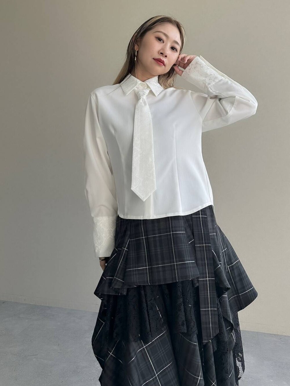 ブラック系のショルダーバッグ、ブラック系のスカート、ホワイト系のシャツ/ブラウスを着用したレディースの夏コーディネートの3枚目の写真