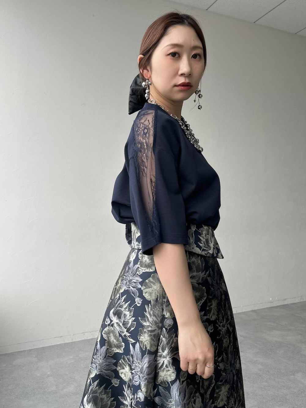 ブラック系のサンダル、ブラック系のハンドバッグ、ブルー系のスカートを着用したレディースの春コーディネートの5枚目の写真