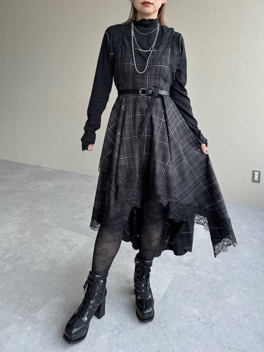 ブラック系のボストンバッグ、ブラック系のワンピース、ブラック系のブーツを着用したレディースの秋コーディネートの6枚目の写真