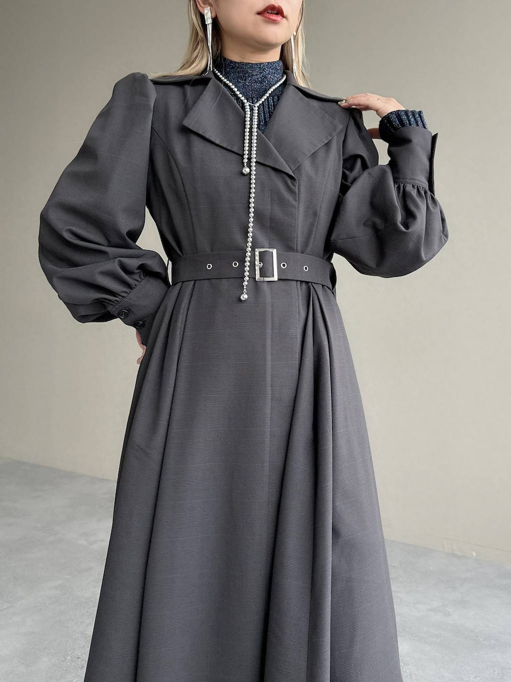 ブルー系のニット/セーター、ブラウン系のボストンバッグ、グレー系のワンピースを着用したレディースの秋コーディネートの4枚目の写真