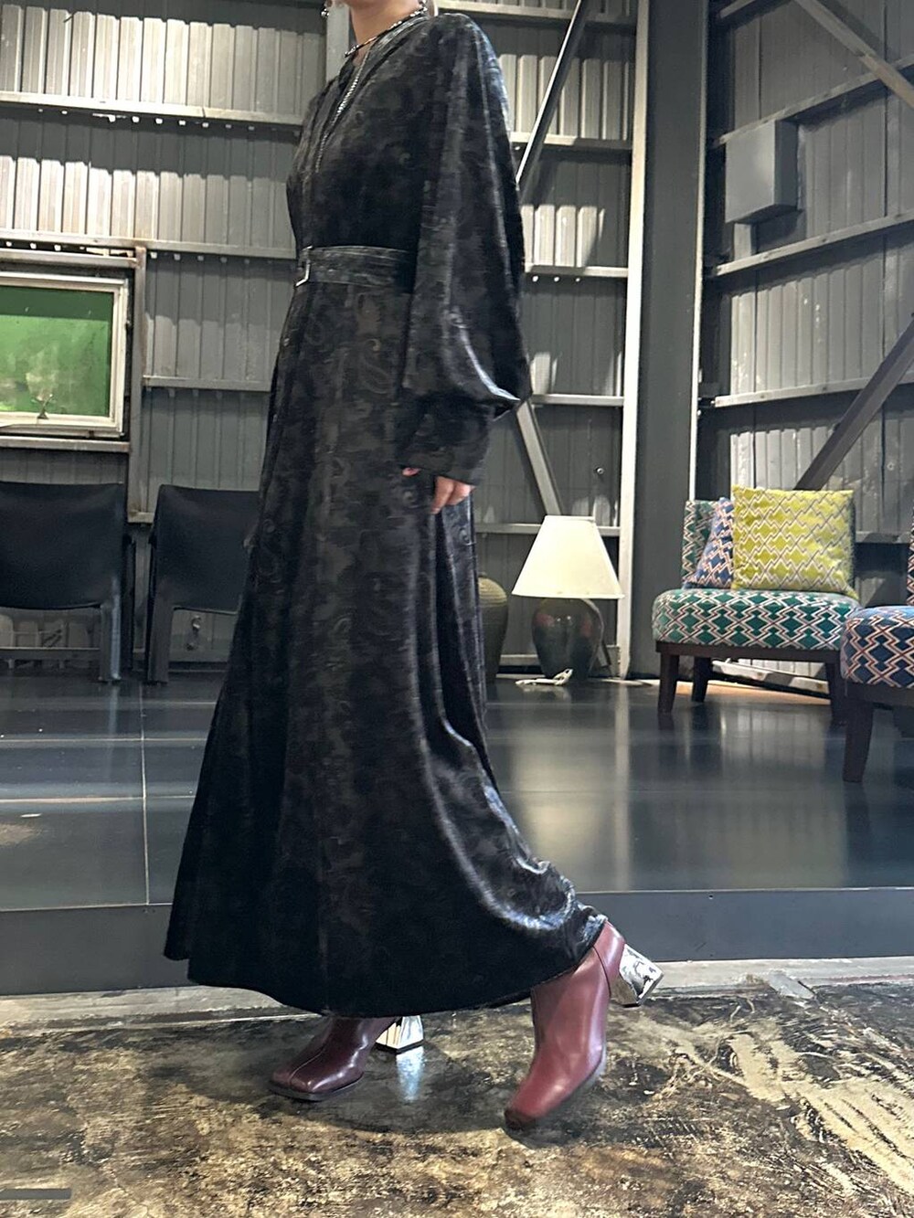 ブラック系のワンピース、レッド系のブーツ、ブラック系のショルダーバッグを着用したレディースの秋コーディネートの6枚目の写真