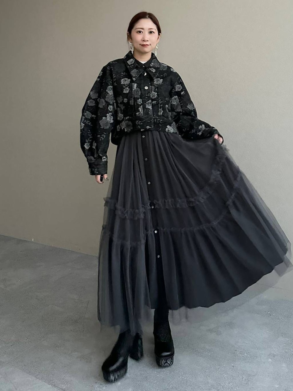 グレー系のブーツ、ブラック系のデニムジャケット、ブラック系のワンピースを着用したレディースの冬コーディネートの2枚目の写真