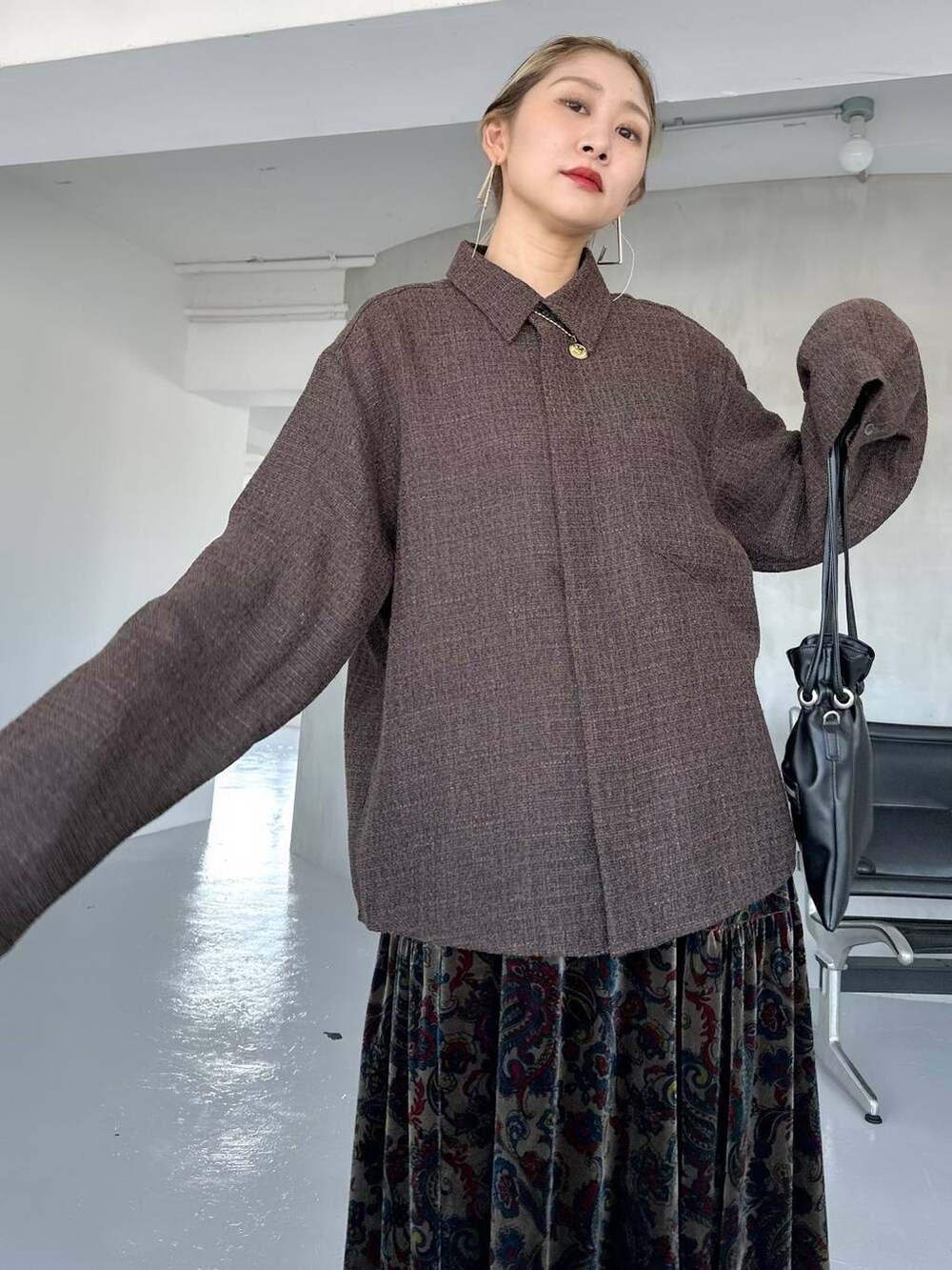 ブラック系のスカート、ブラック系のブーツ、ブラウン系のシャツ/ブラウスを着用したレディースの秋コーディネートの5枚目の写真