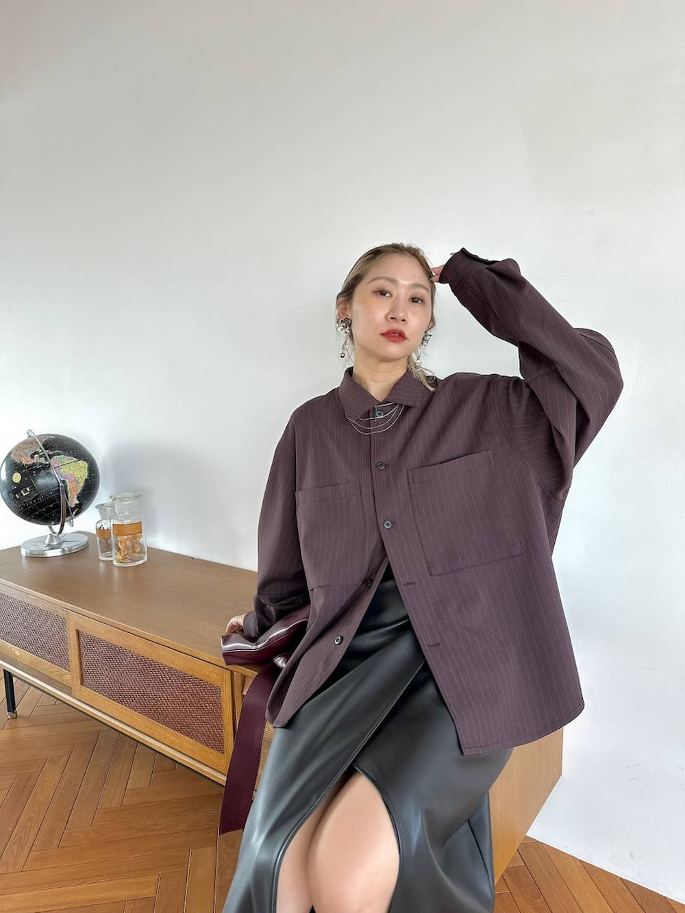 レッド系のトートバッグ、ブラック系のスカート、シルバー系のブーツを着用したレディースの夏コーディネートの5枚目の写真