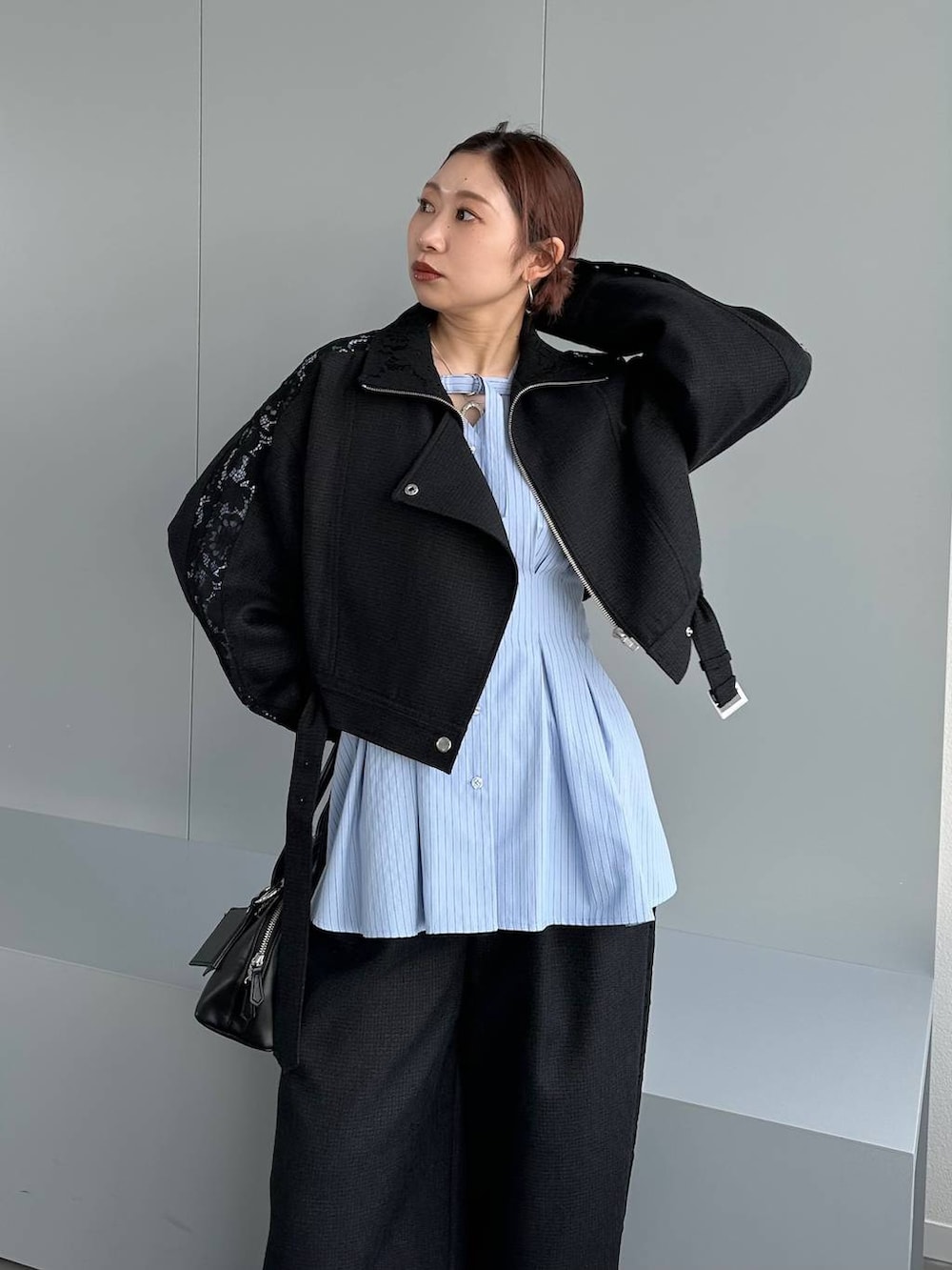 ブラック系のハンドバッグ、ブラック系のスラックス、ブラック系のブルゾンを着用したレディースの春コーディネートの9枚目の写真