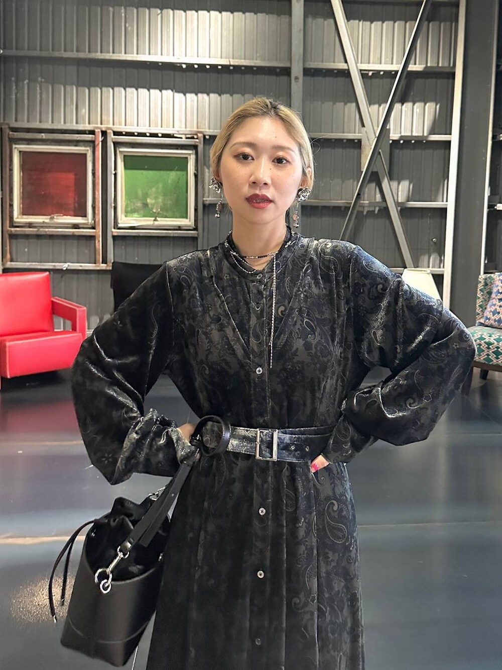 ブラック系のワンピース、レッド系のブーツ、ブラック系のショルダーバッグを着用したレディースの秋コーディネートの3枚目の写真