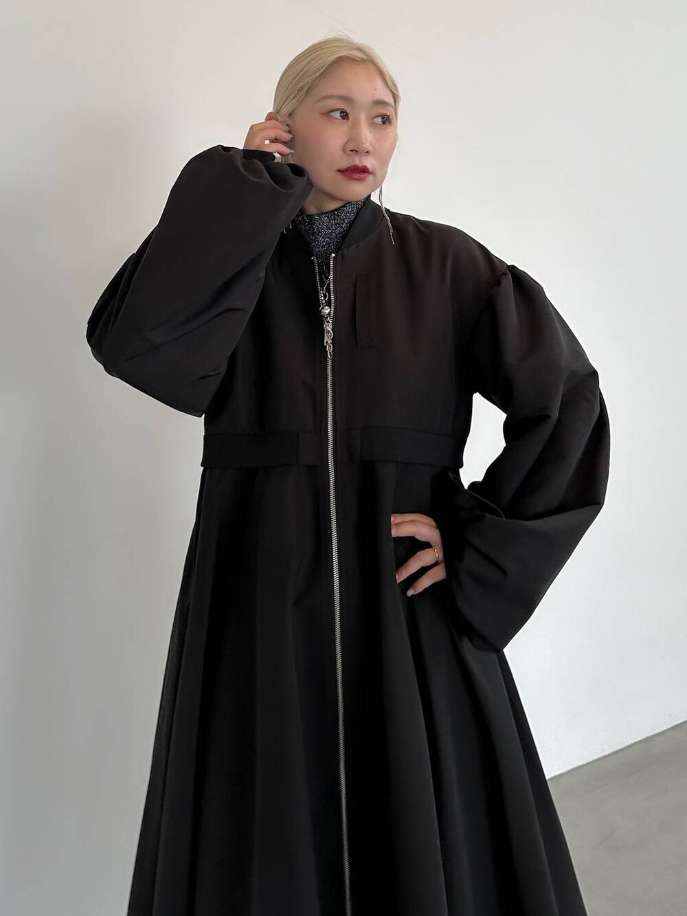 ブラック系のニット/セーター、ブラック系のブーツ、ブラック系のブルゾンを着用したレディースの秋コーディネートの4枚目の写真