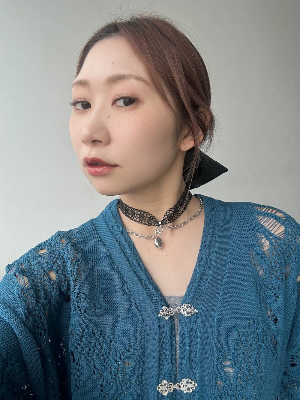 ブラック系のスカート、ブラック系のサンダル、ブルー系のデニムパンツを着用したレディースの春コーディネートの9枚目の写真