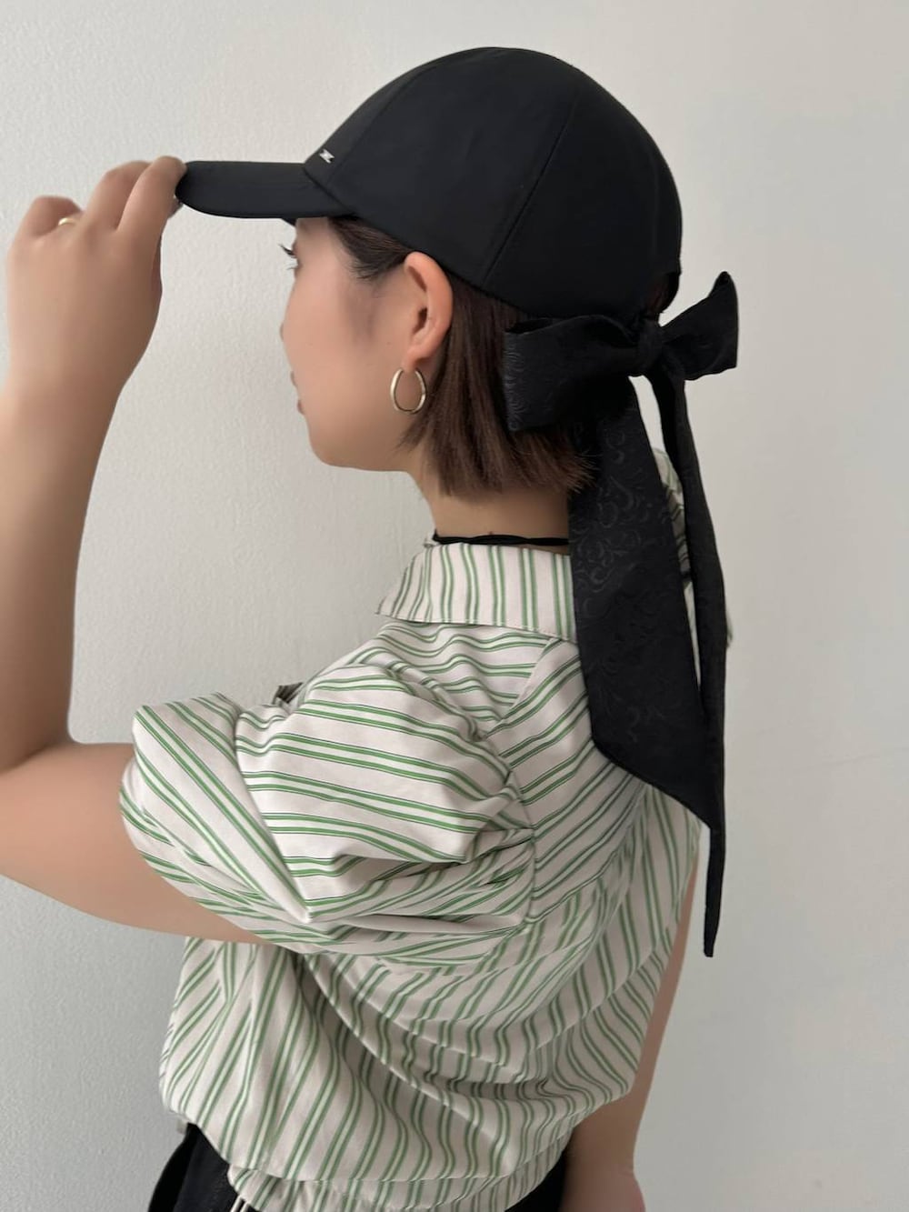 ブラック系のキャップを着用したレディースの春コーディネートの3枚目の写真
