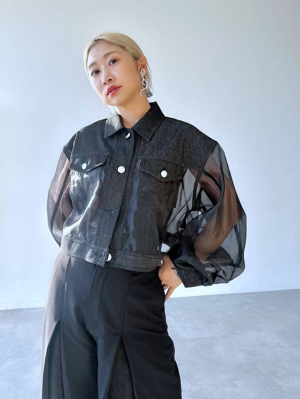 ブラック系のスラックス、ブラック系のパンプス、ブラック系のブルゾンを着用したレディースの夏コーディネートの3枚目の写真