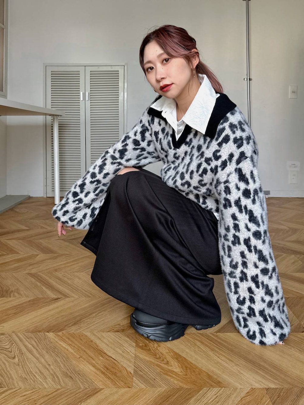 ブラック系のブーツ、ホワイト系のシャツ/ブラウス、ブラック系のスカートを着用したレディースの秋コーディネートの3枚目の写真