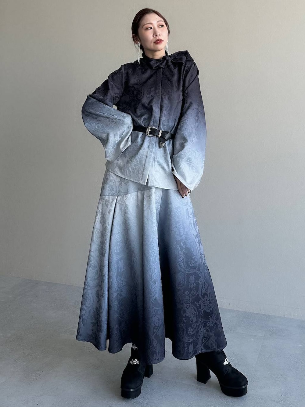 ブラック系のブーツ、ブラック系のシャツ/ブラウス、ブラック系のスカートを着用したレディースの冬コーディネートの8枚目の写真