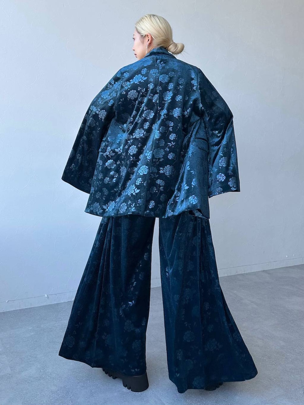 ホワイト系のシャツ/ブラウス、ブルー系のテーラードジャケット、ブラック系のブーツを着用したレディースの冬コーディネートの2枚目の写真