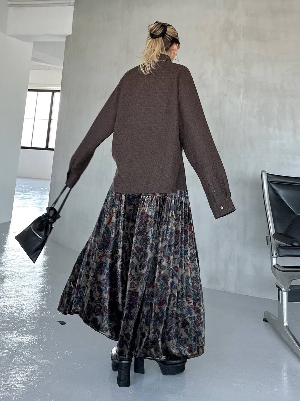 ブラック系のスカート、ブラック系のブーツ、ブラウン系のシャツ/ブラウスを着用したレディースの秋コーディネートの3枚目の写真