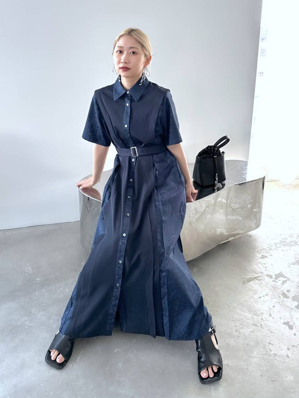 ブルー系のワンピース、ブラック系のショルダーバッグ、ブラック系のサンダルを着用したレディースの春コーディネートの5枚目の写真