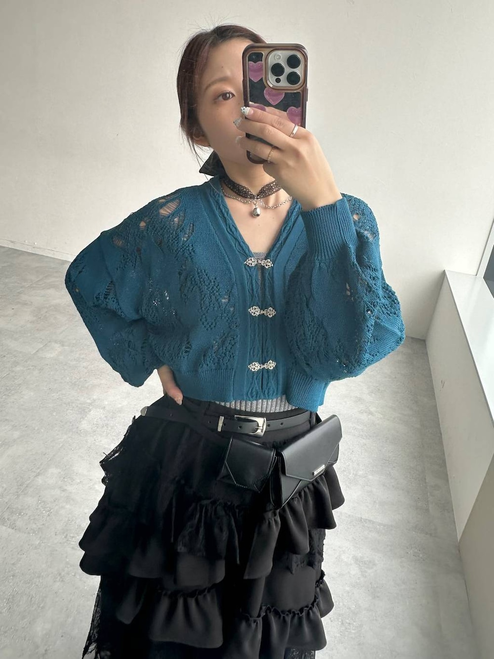 ブラック系のスカート、ブラック系のサンダル、ブルー系のデニムパンツを着用したレディースの春コーディネートの8枚目の写真