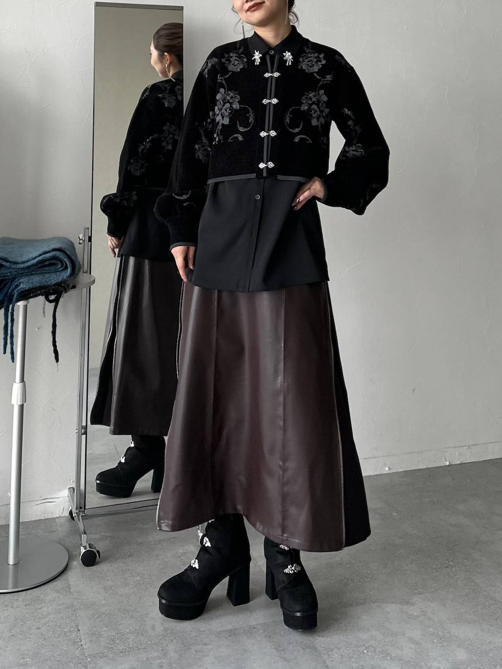 ブラウン系のスカート、ブラック系のブーツを着用したレディースの秋コーディネートの3枚目の写真