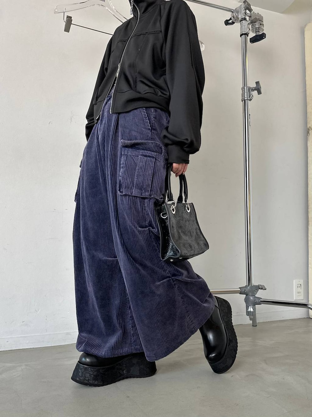 ブラック系のショルダーバッグ、ブルー系のパーカー、ブルー系のカーゴパンツを着用したレディースの秋コーディネートの6枚目の写真