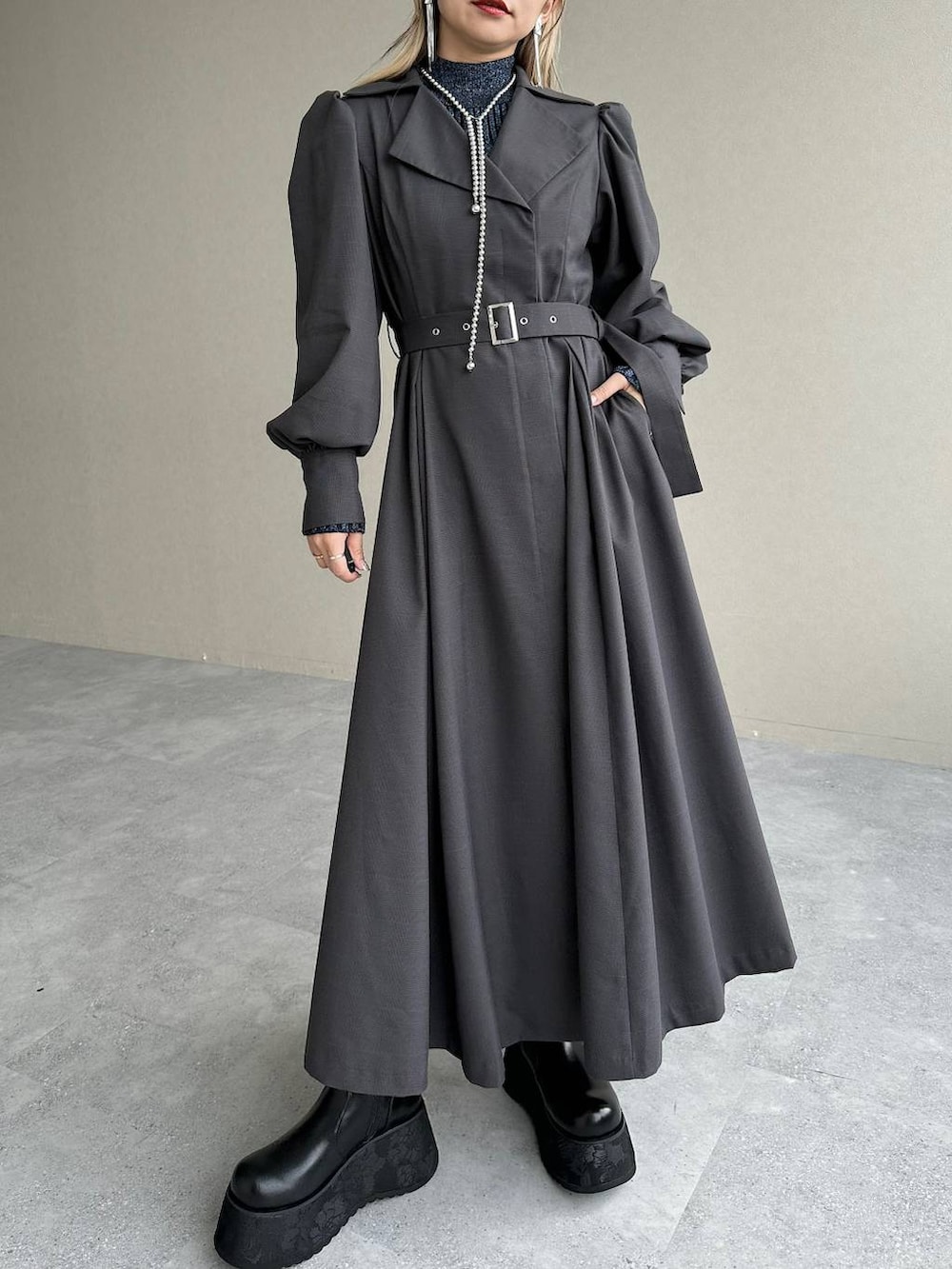 ブルー系のニット/セーター、ブラウン系のボストンバッグ、グレー系のワンピースを着用したレディースの秋コーディネートの6枚目の写真