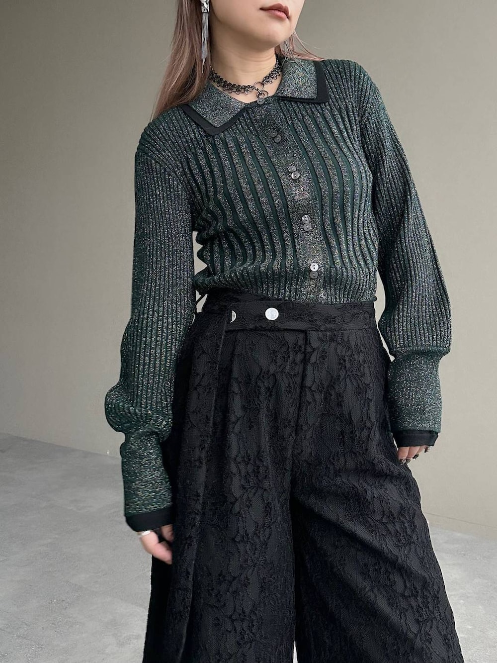 グレー系のブーツ、グリーン系のカーディガン/ボレロ、シルバー系のイヤリングを着用したレディースの秋コーディネートの4枚目の写真