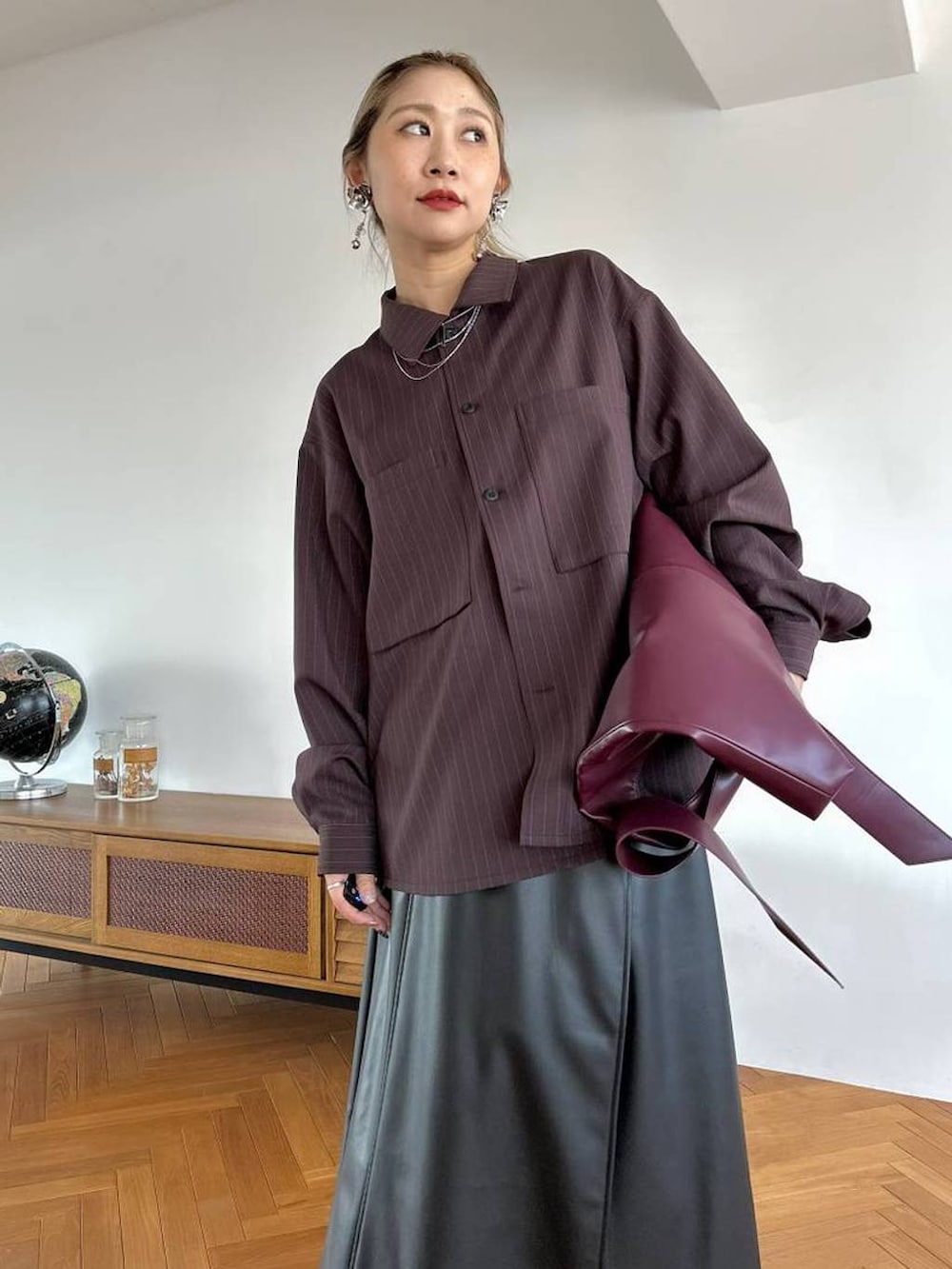 レッド系のトートバッグ、ブラック系のスカート、シルバー系のブーツを着用したレディースの夏コーディネートの4枚目の写真