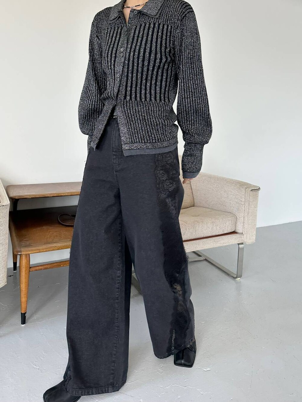 ブラック系のショルダーバッグ、ブラック系のデニムパンツ、ブラック系のブーツを着用したレディースの秋コーディネートの7枚目の写真